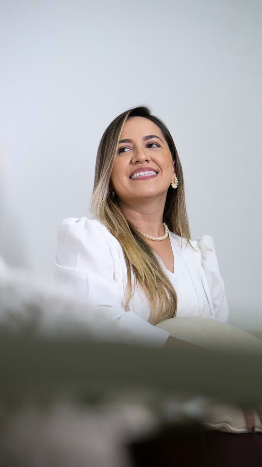 Dra. Larissa Lima sorrindo em seu consultório